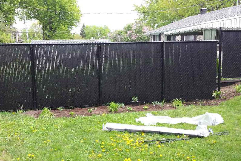 Installation de clôture Frost noire en maille de chaine 6 pieds de haut, avec installation de lattes intimité, travaux effectués a Boucherville sur la rive-sud de Montréal