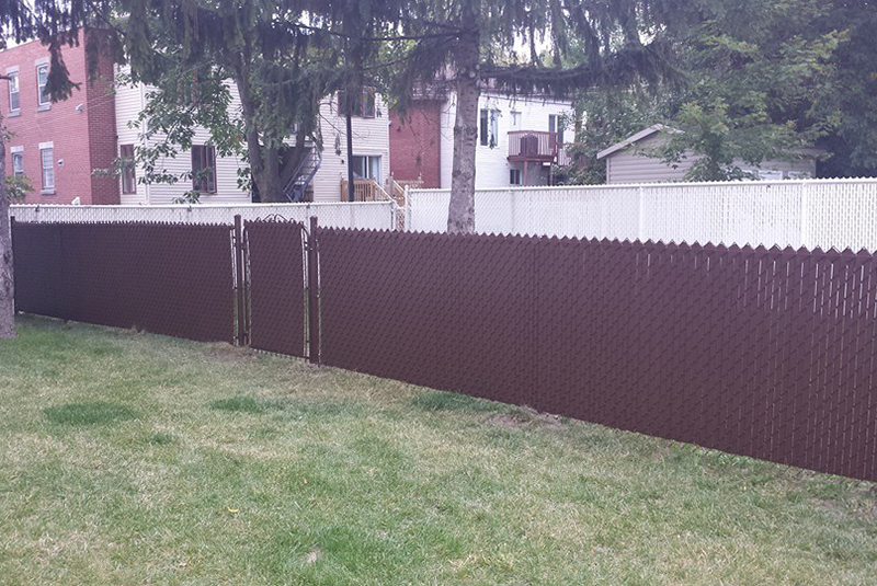 Installation de clôture et barrière Frost brune, en maille de chaine 4 pieds de haut, avec installation de lattes intimité, travaux effectués a Longueuil sur la rive-sud de Montréal